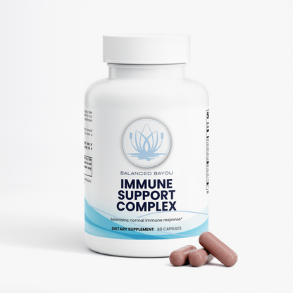 A white bottle of Balanced Bayou Immune Support Complex dietary supplement with three pinkish-brown capsules placed in front, on a clean white background.