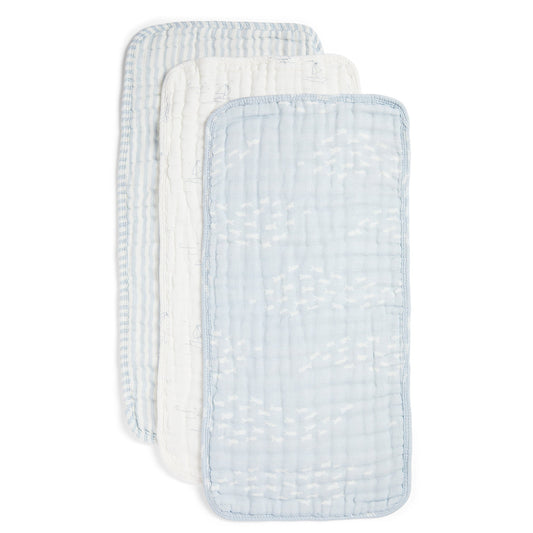 Three reusable muslin baby wipes stacked diagonally, featuring a light blue and white patterned front wipe and two white wipes with light blue stripes behind it, on a solid white background.