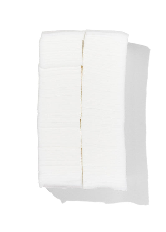 A stack of white textured paper napkins or tissue-like paper products, photographed from above on a white background with a soft shadow.