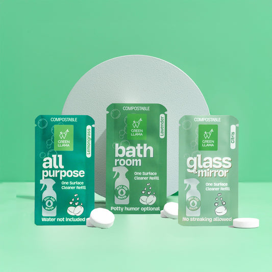Three green packaging containers labeled 'all purpose', 'bathroom', and 'glass & mirror' on a light green background.