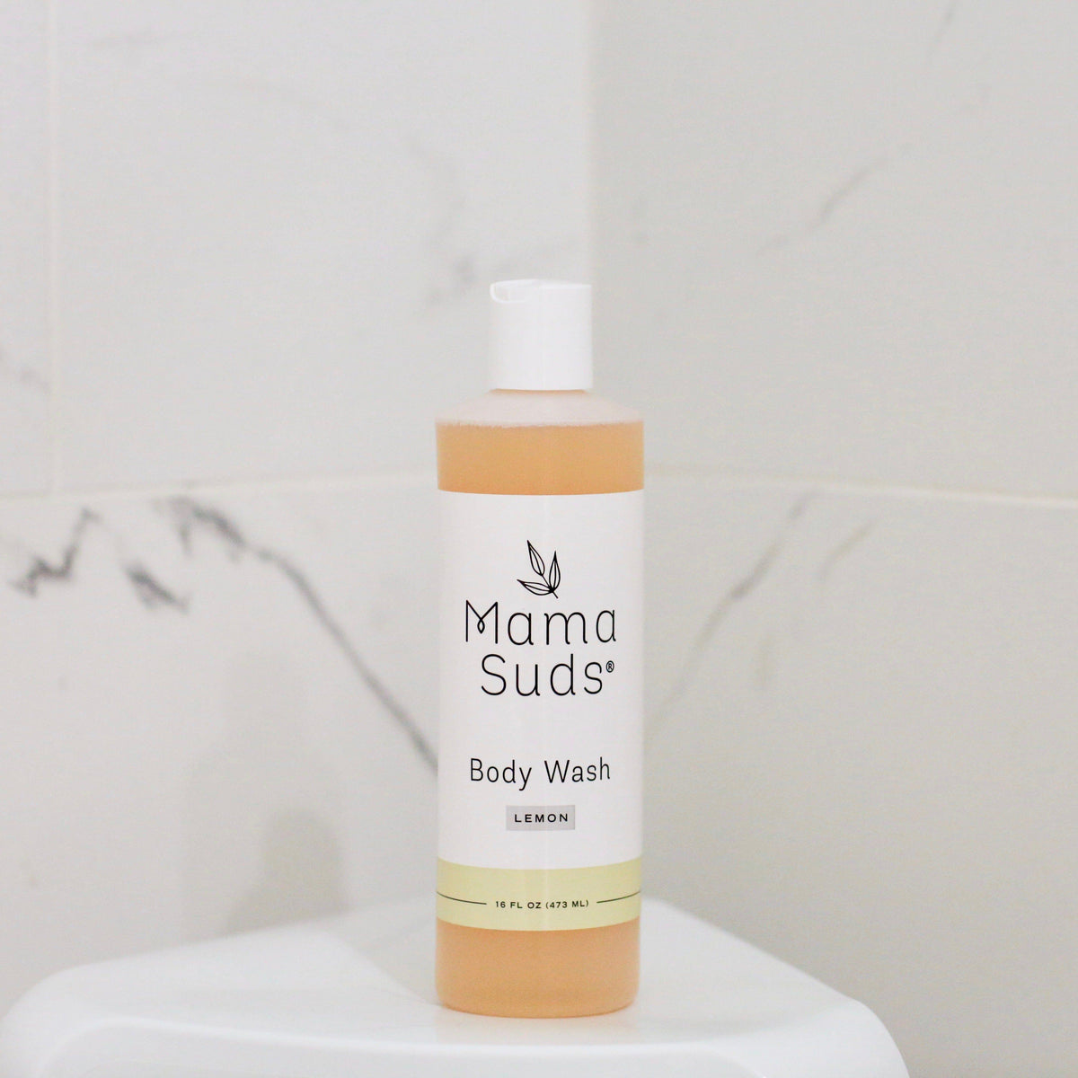Mama Suds body wash bottle on a white surface with a light gray background