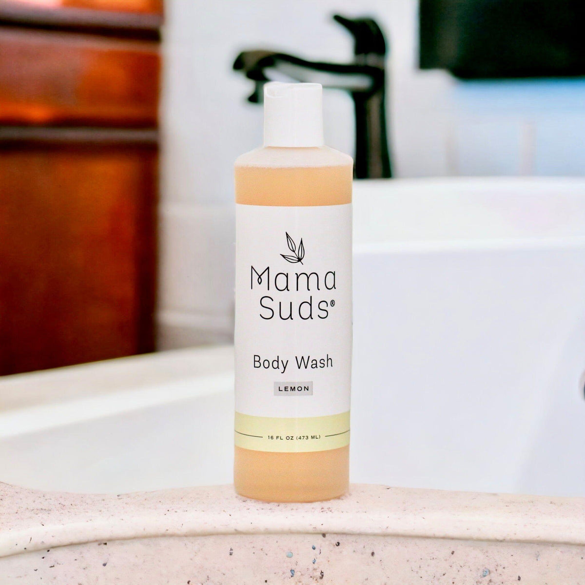 Mama Suds body wash bottle on a bathroom counter with a blurred background