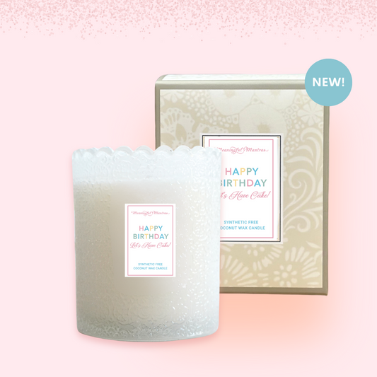 Frosted birthday candle with decorative packaging on a pink background