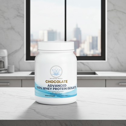 A white tub of Advanced Nutrition Chocolate Advanced 100% Whey Protein Isolate sits on a marble countertop in a modern kitchen setting with a city skyline visible through the window behind it.