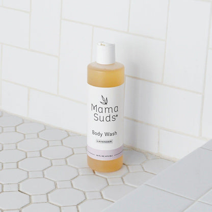 Mama Suds body wash bottle on a tiled bathroom floor