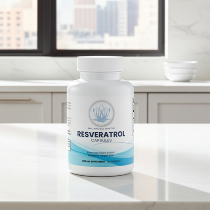 A white bottle of Resveratrol capsules from Balanced Bayou stands on a white countertop in a bright kitchen setting with a window and city view in the background.